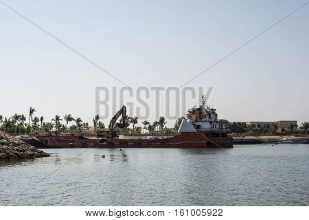 Boat dredger creating land coastline in Souly Bay Salalah Oman