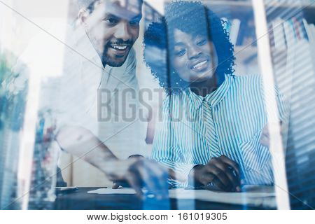 Concept of double exposure.Two young coworkers working together in a modern office.Black business partners discussing new startup project.Skyscraper office building blurred on background.Horizontal