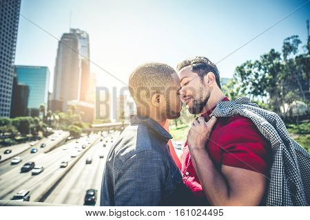 Homosexual couple at a romantic date outdoors - Multi-ethnic gay couple in love flirting and having fun