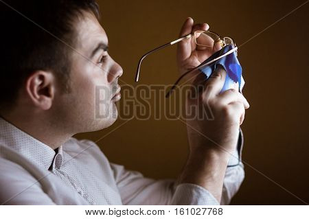 the man wipes with a rag of a lens of computer glasses.
