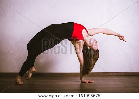 Young pretty woman in black leotard practicing yoga