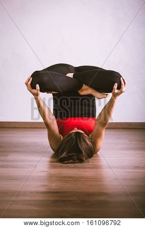 Young pretty woman in black leotard practicing yoga