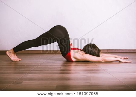 Young pretty woman in black leotard practicing yoga