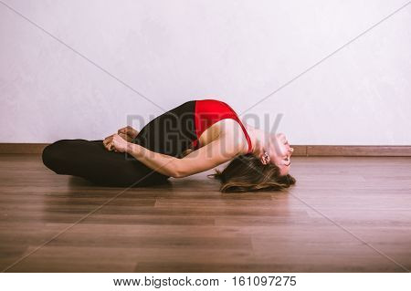 Young pretty woman in black leotard practicing yoga