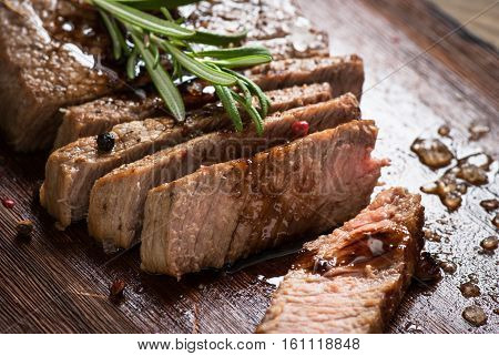 Sliced beef steak medium rare with balsamico and rosemary.