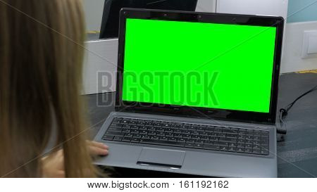 Woman looking at laptop with green screen. Business, communication, freelance and internet concept