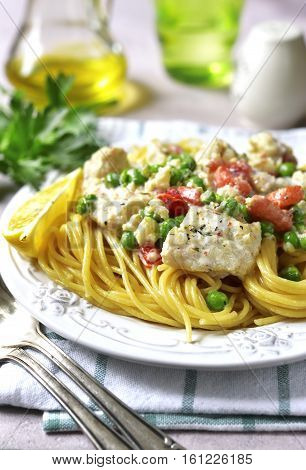 Codfish In A Cream Sauce With Vegetables Garnished With Spaghetti.