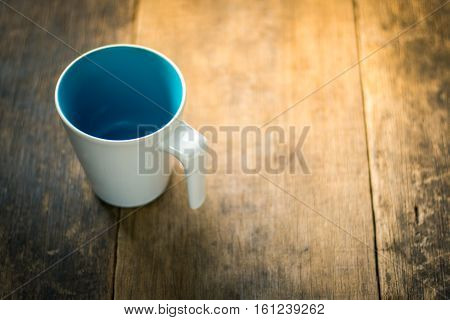 White Cup Inside Blue Colored On Wooden Background
