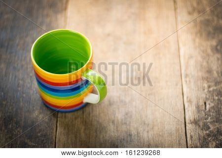 Rainbow cup green inside on wooden background