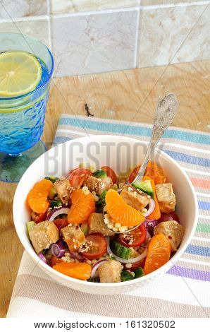 Healthy Salad Bowl With Cuscus, Tomatoes, Cucumber, Chicken, Tangerine And Sesame Seeds