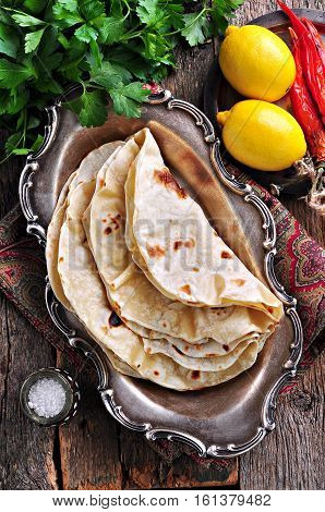 Homemade bread (pita, lavash bread) on old wooden background.