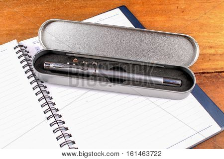 notebook with pen on old wooden table