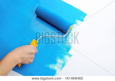 Decorator's hand painting wall with roller