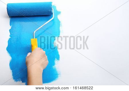 Decorator's hand painting wall with roller