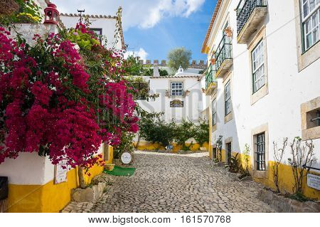 OBIDOS PORTUGAL - OCTOBER 15 2015: The street of Obidos in Portugal popular tourist destination because of its a well-preserved medieval architecture