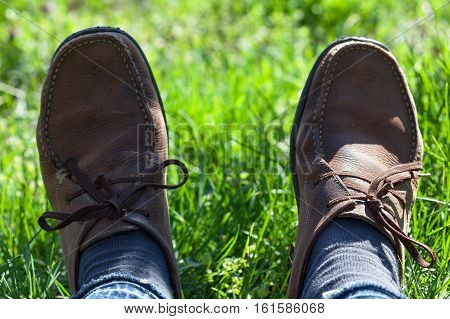 man in brown shoes lying in the green grass