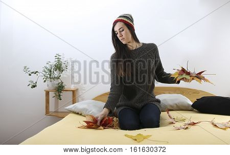 Hipster is Girl collecting leaves in the room