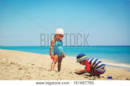 kids play with sand on summer tropical beach