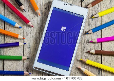 BUNGKAN THAILAND - NOVEMBER 10 2015: smart phone with Facebook on screen and color pencil around