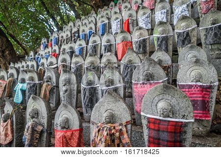 Buddahist statues with some red  clothes on