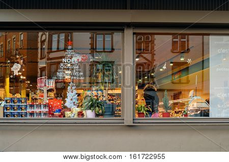 STRASBOURG FRANCE - DEC 1 2016: Carrefour supermarket at the evening with Christmas tree sticker on the windows and customers buying diverse food and non-food products. Carrefour is the largest chain of stores in France