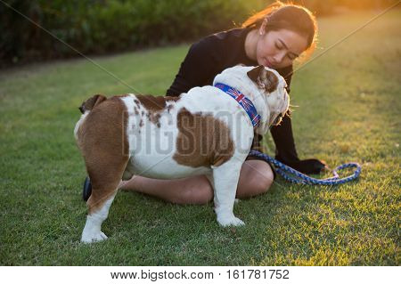 Woman and Bulldog sit on the grass