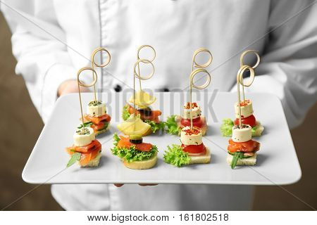 Chef holding plate with assorted canapes closeup