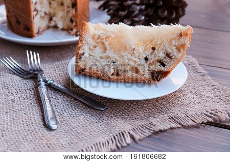 Panettone Traditional Italian Christmas cake on rustic background with vintage fork. Copy space.