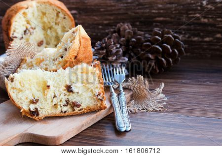 Panettone Traditional Italian Christmas cake on rustic background with vintage fork. Copy space.
