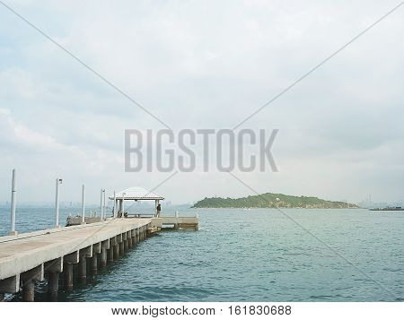 concrete pier on sea/ocean with blue sky background in Thailand.