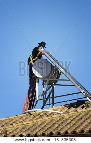 a worker installs rooftop solar panels ecology