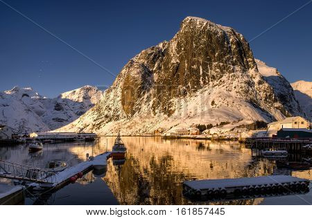 Snowy Lilandstinden mountain over Hamnoy village in sunset light Lofoten