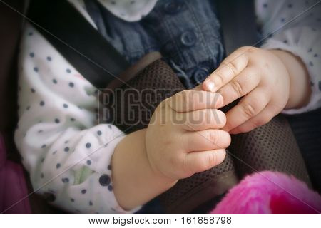 the hands of the child seated in the child seat 
