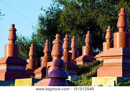 Gravesites with tall headstones taken in a Buddhist Cemetery