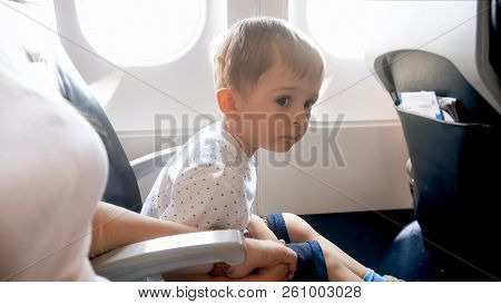 Little Toddler Boy Holding By Hand His Mother During First Flight In Airplane
