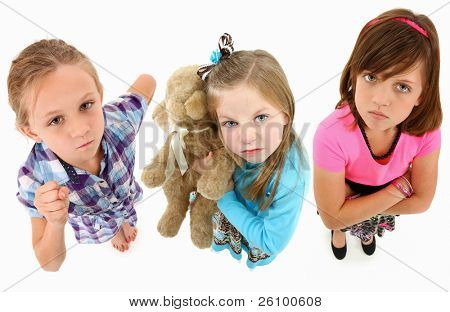 Adorable groupe de filles de 7 ans en colère sur fond blanc en levant vers la caméra.  Vue de dessus 
