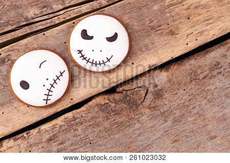 Jack Skellington Cookies On Wooden Background. Round Gingerbread Biscuits With Halloween Faces, Copy