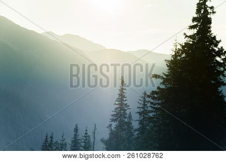 A Dreamy, Hazy Landscape Of A Mountains Close To Sunset. Sun Flase And Misty Look In Blue Tones. Mo
