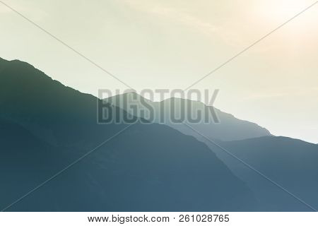 A Dreamy, Hazy Landscape Of A Mountains Close To Sunset. Sun Flase And Misty Look In Blue Tones. Mo
