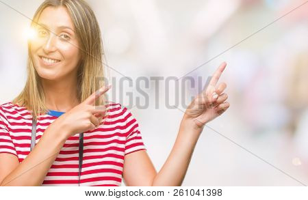 Young beautiful woman taking pictures using vintage photo camera over isolated background smiling and looking at the camera pointing with two hands and fingers to the side.