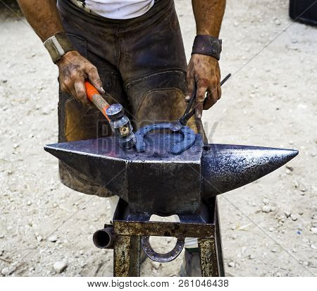 Maniscalco Forge A Horseshoe With The Hammer On The Anvil. Selective Focus