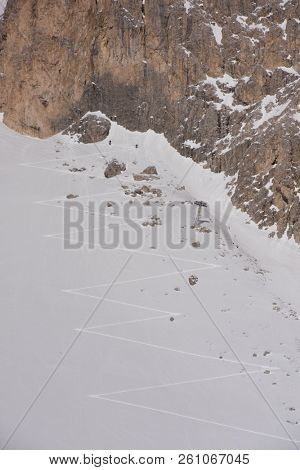 hiking touring ski tracks in snow climbing to mountain top at beautiful winter day with fresh snow