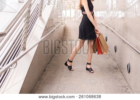 Lifestyle Concept,confident Girl In Blackdress Smling And Holding Shopping Bags In City,close Up