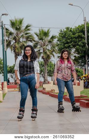 Two Chubby Girls With Inline Skates In The Park