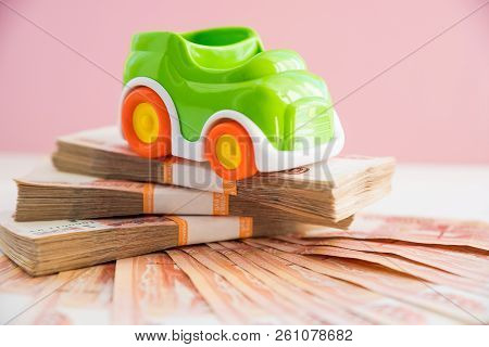 Toy Car Model And Money, Russian Money. Car Expenses Concept.the Model Of The Car On The Background 