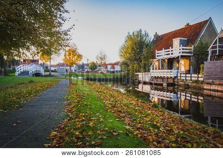 View Of The Authentic  Village, With Canal, Wooden Small Footbridge Wooden White Bridge And Houses. 