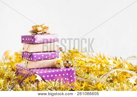 Beige And Violet (purple) Gift Boxes (presents) Stack With Ribbon With Golden Christmas Decoration