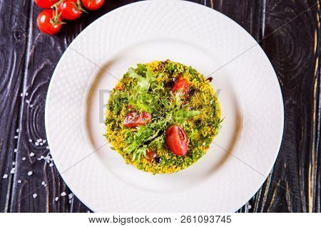 Salad From Bulgur And Fresh Vegetabes On White Plate In Restaurant