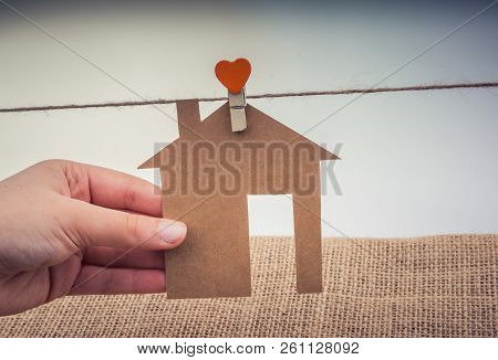 Hand Holding A Aper House On A Canvas Background
