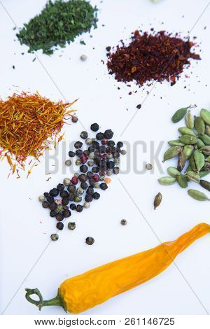 Dry Spices And Herbs In Glass Jar With A Cork, A Bowl Of Cherry Tomatoes And Chili Peppers, White Ba
